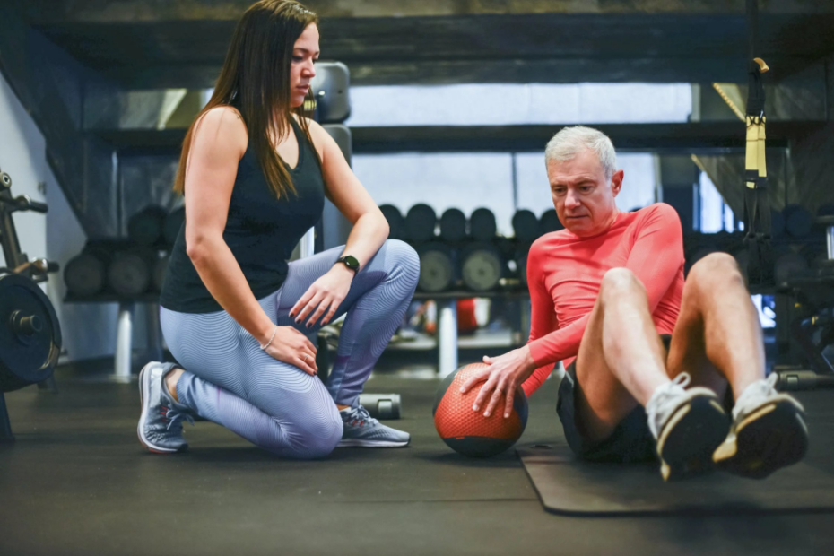 A personal trainer in a gym with a client