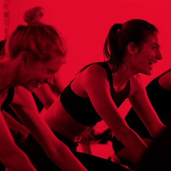 Women participating in a Spinning indoor cycling fitness class